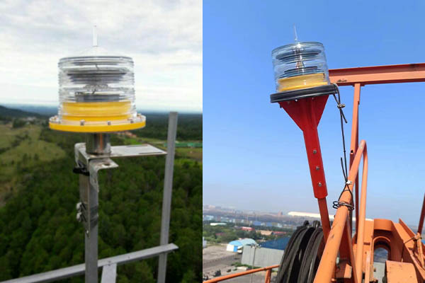 Solar Obstruction Light for Communication Tower YFFY Lights Pair of aerial obstruction lights mounted on metal poles left on a scaffold with a yellow base right on an orange construction framework against a blue sky