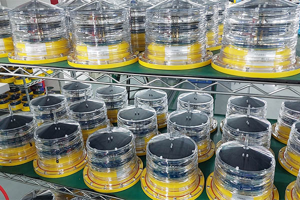 solar aviation warning light YFFY Lights Rows of clear plastic cylinders with yellow bases on metal shelving in a workshop or factory setting