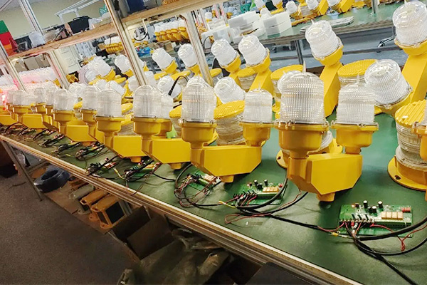 LED Obstruction Light YFFY Lights Row of yellow beacon light housings with clear lenses on an electronics assembly line