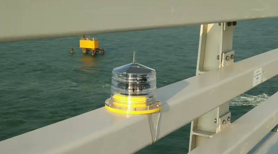 Solar Marine Lantern YFFY Lights YFFY Lights Clear dome navigation beacon with a yellow base mounted on a metal railing over the sea informational